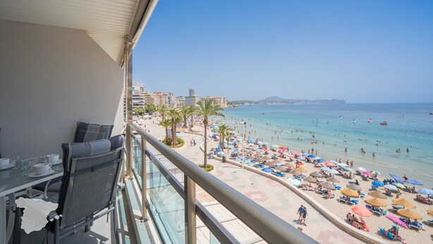 A balcony with a view of a beach, palm trees, and a cityscape in the background. - CostaBlancaDreams - Nineteen / Frentemar in Calpe (Calpe)