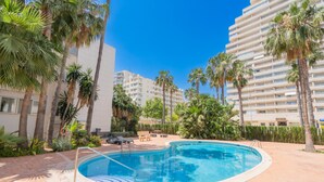 A swimming pool surrounded by palm trees and a multi-story building. - CostaBlancaDreams - Nineteen / Frentemar in Calpe (Calpe)