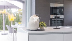 A modern kitchen with a white countertop, a large globe, and a potted plant. - CostaBlancaDreams - Villa Gran Sol en Calpe (Calpe)