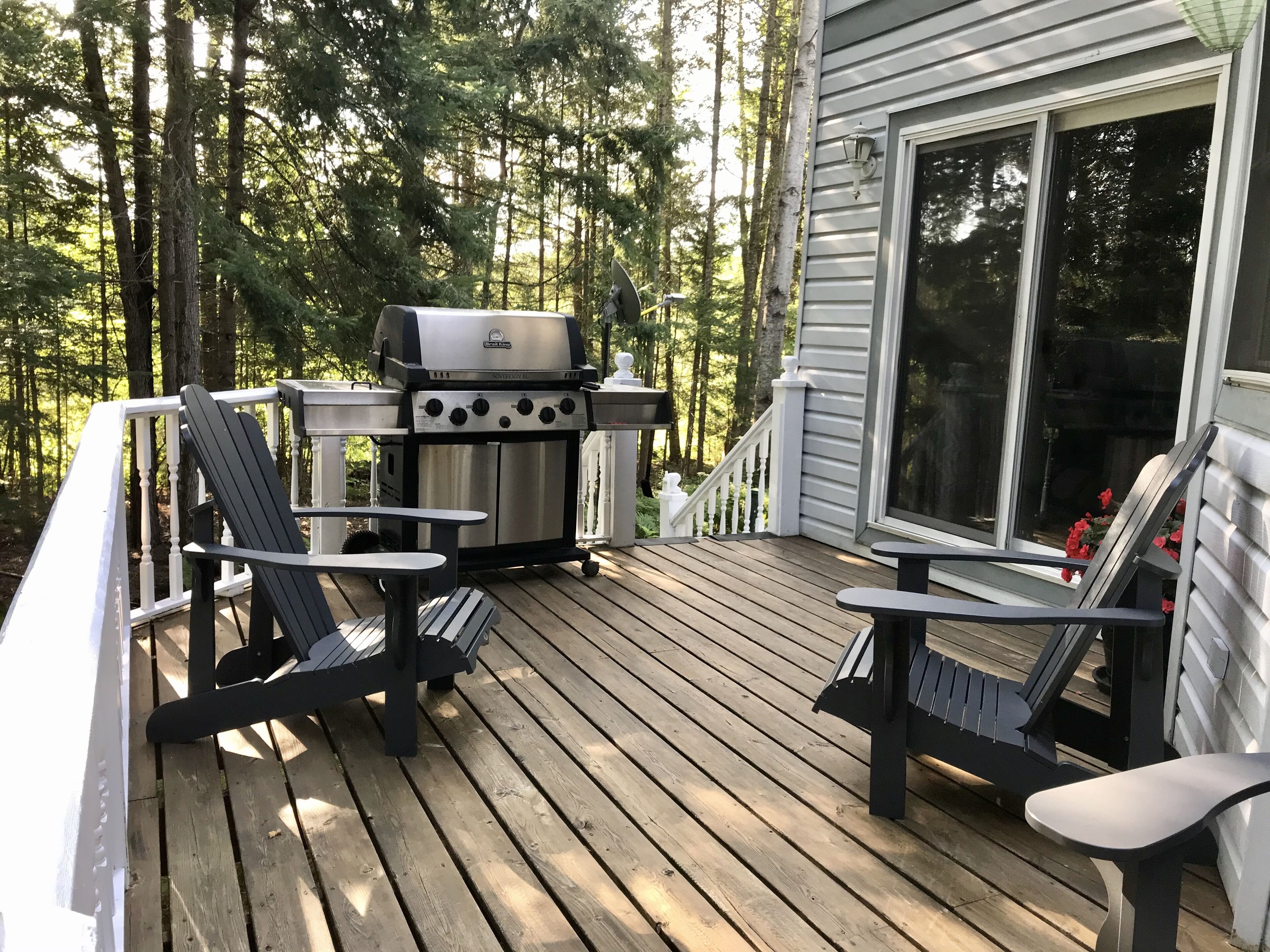 Backyard deck with BBQ and muskoka chairs