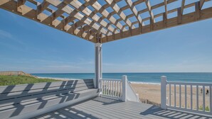A wooden deck with a white railing overlooking a beach. - 5373 - Wench's Pad 4 - Luxury Oceanfront Retreat | Sleeps 40 (Kill Devil Hills)