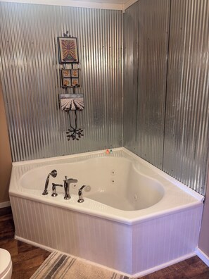 Une salle de bain comprenant une baignoire sur pieds, des toilettes et un espace douche.