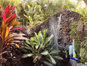 A rock garden with a waterfall, various plants, and a small pond. - POIPU BEACH HOME, Kauai's famous sunny south shore. (Koloa)
