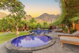 Una piscina al aire libre, camas de piscina gratis, sombrillas