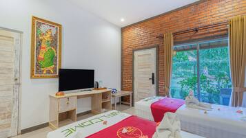 Een kamer met een bakstenen muur, een televisie, twee bedden, een bureau en een raam met uitzicht op groen.