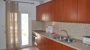 A kitchen with wooden cabinets, a stainless steel sink, a coffee maker, and a toaster. - Lovely 3-Bed House in Bali (Bali)