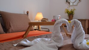 A hotel room with a bed, a wooden nightstand, a lamp, a cup, and a vase with flowers. - Lovely 3-Bed House in Bali (Bali)