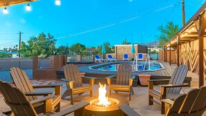 An outdoor patio with a fire pit, lounge chairs, and a pool area. - Large Family Retreat Pool Hot Tub Game Room Sauna (Lake Havasu City)