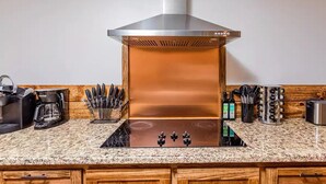 A kitchen with a stainless steel range hood, a granite countertop, and various kitchen appliances. - Large Family Retreat Pool Hot Tub Game Room Sauna (Lake Havasu City)