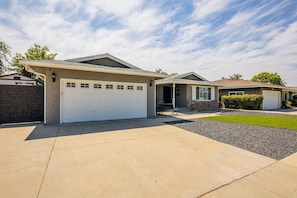 A two-story house with a garage, a covered porch, and a well-maintained lawn.