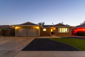 A residential house with a garage, a well-maintained lawn, and a driveway.