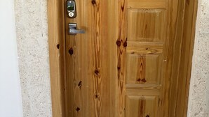 A wooden door with a keyhole and a doorbell.