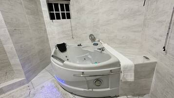 Een moderne badkamer met een vrijstaand bad, een handdouche en een handdoekhouder.