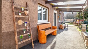 A wooden bench, a wooden ladder, and a window with a view of the garden. - Apartment "Am Sersbach" (Forbach)