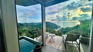 A balcony with a glass door, a table, and two chairs.