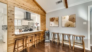 Een moderne keuken met houten details, een bar en twee grote decoratieve parasols aan de muur.