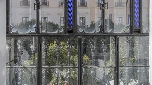 A window with a view of a building with balconies and a decorative blue zigzag pattern. - Julio Cesar Great Apartment Of High Qualities Heart Of Seville (Sevilla)