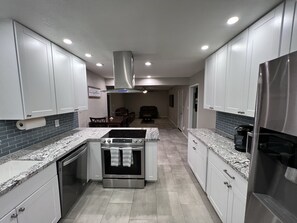 A modern kitchen with white cabinets, a stainless steel stove, and a built-in oven. - Comfortable and fun! Pool, game room, outdoor living spaces, great location ++++ (Phoenix)