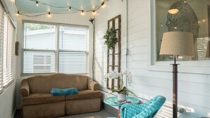 A cozy room with a brown sofa, a small round table, and a floor lamp. - Sister Lake Cottages - private cottage community! (Dowagiac)