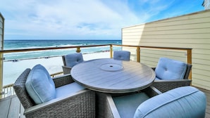 A deck with a round table and wicker chairs, overlooking the ocean. - Summerhaven 3 | Beach Front Townhome with Free Chairs through October! | New Coastal Design! | Tail-Wagging Approved (Miramar Beach)