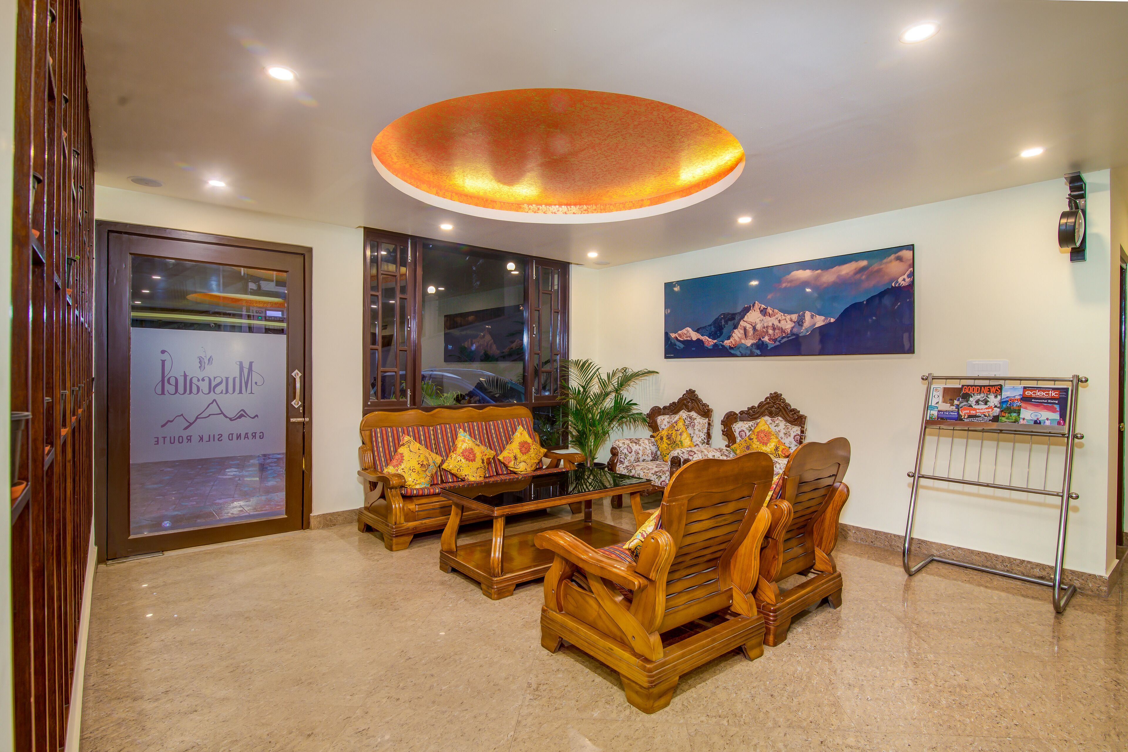 A lobby with wooden furniture, a ceiling light, a framed picture, and a sign.
