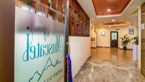 A hotel reception area with a glass door displaying the name 'Grand St. K' and a reception desk. - Muscatel Grand Silkroute 300 Mts MG Marg (Gangtok)