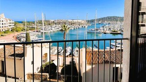 A marina with boats, a clear blue sky, and buildings in the background.