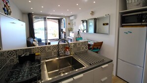 A compact kitchen with a sink, a stove, and a refrigerator.