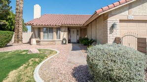 A single-story house with a tiled roof, a front porch, and a garage.
