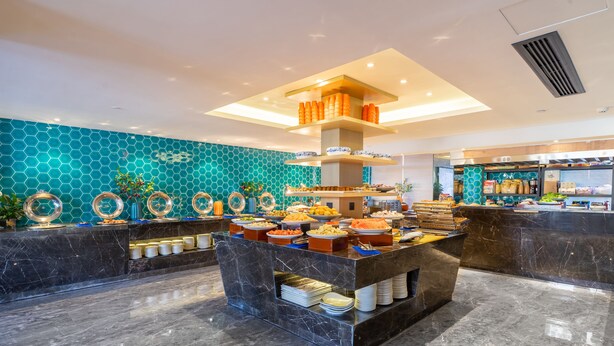 A buffet area with a variety of food items and a decorative wall with hexagonal patterns.