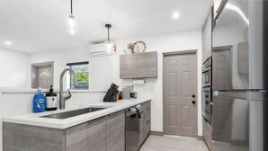 Een moderne keuken met een groot eiland, roestvrijstalen apparatuur en een minimalistisch design.