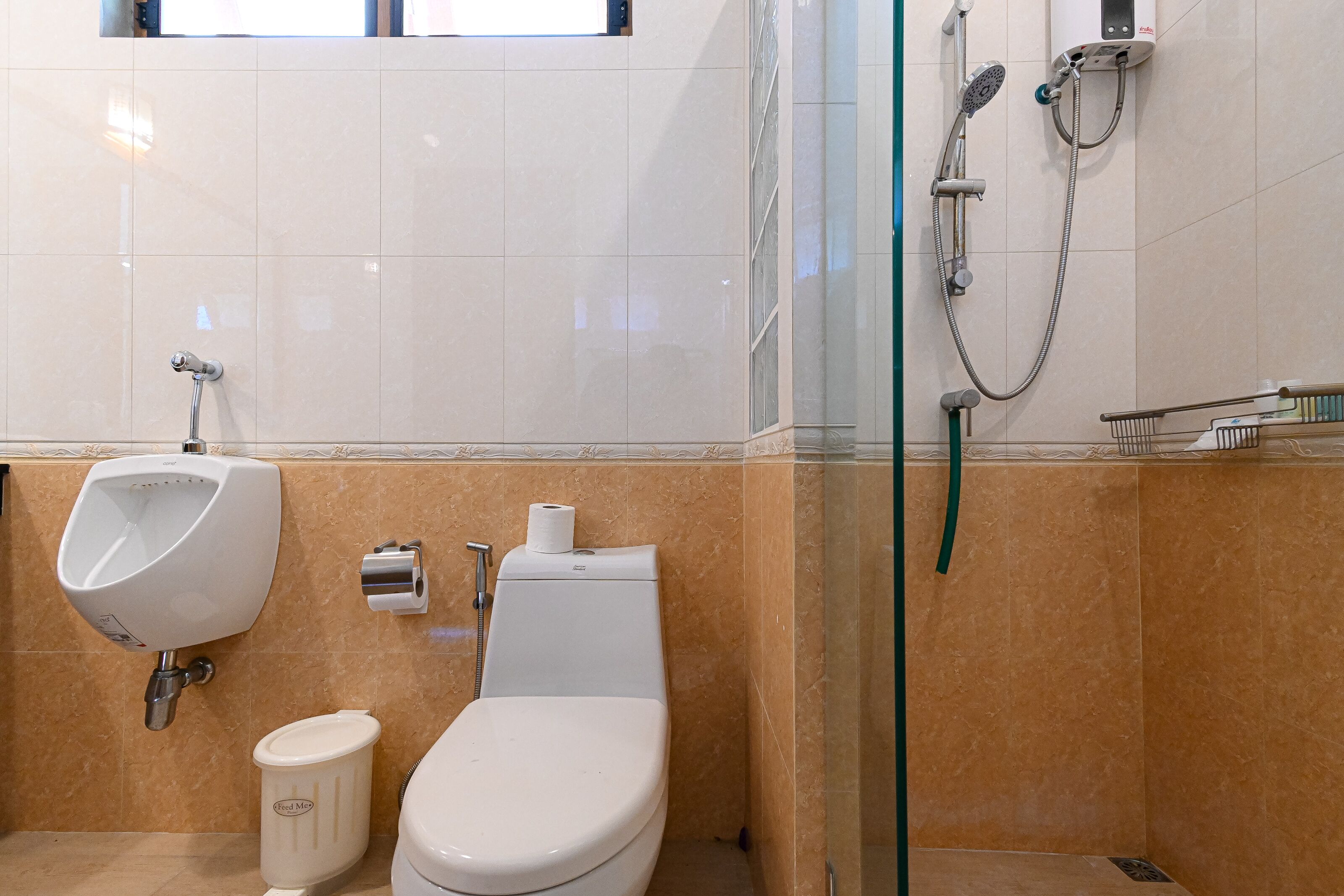 Un baño moderno con orinal, inodoro y ducha.