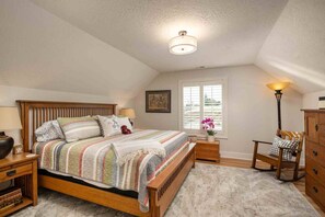 A bedroom with a wooden bed, a nightstand, a lamp, a chair, and a dresser. - Spectacular Villa on 25 Acre Orchard, Pergola w/ Fireplace, Private Hot Tub, Pet Friendly, BBQ (Aurora)