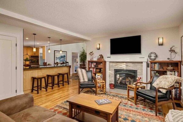A modern living room with a fireplace, a bar area, and a comfortable seating arrangement. - Spectacular Villa on 25 Acre Orchard, Pergola w/ Fireplace, Private Hot Tub, Pet Friendly, BBQ (Aurora)