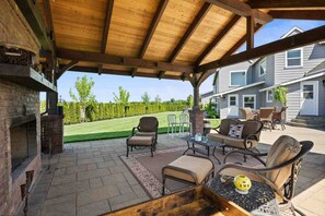 An outdoor patio with a wooden pergola, seating area, and a fire pit. - Spectacular Villa on 25 Acre Orchard, Pergola w/ Fireplace, Private Hot Tub, Pet Friendly, BBQ (Aurora)