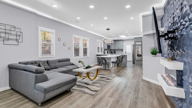 A modern living room with a grey sectional sofa, a white coffee table, and a patterned rug. - Spacious 3BR House in Charlotte (Charlotte)