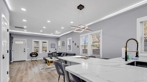 A modern kitchen with a marble countertop, a built-in sink, and a pendant light. - Spacious 3BR House in Charlotte (Charlotte)