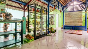 Una habitación amplia con techo alto, una vitrina de vidrio llena de diversos objetos y un ventilador en el suelo.