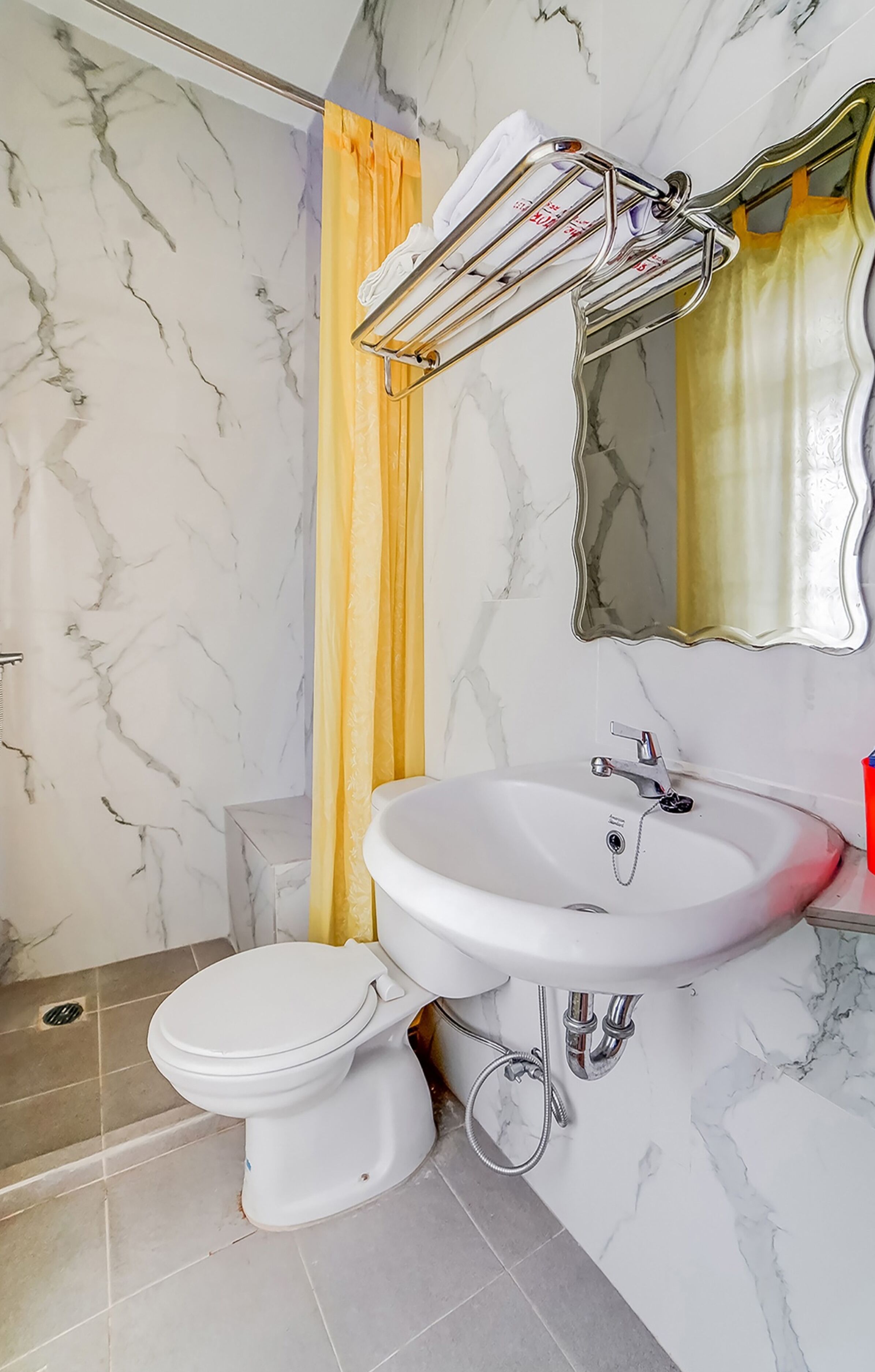 A bathroom with a white toilet, a sink with a mirror above it, and a shower curtain.
