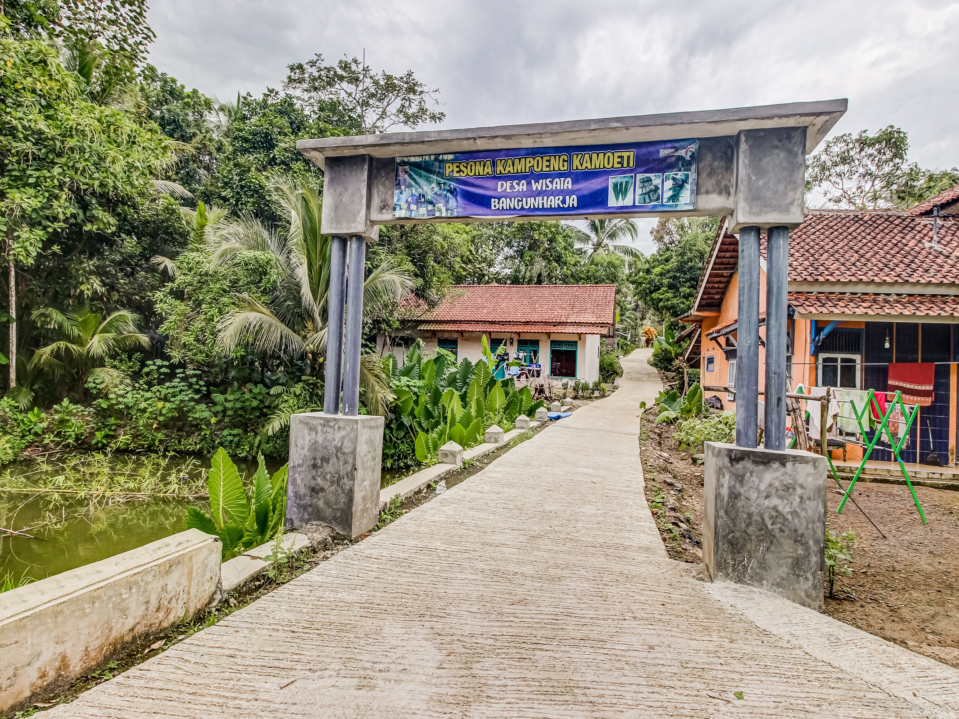 A pathway leading to a building with a signboard.