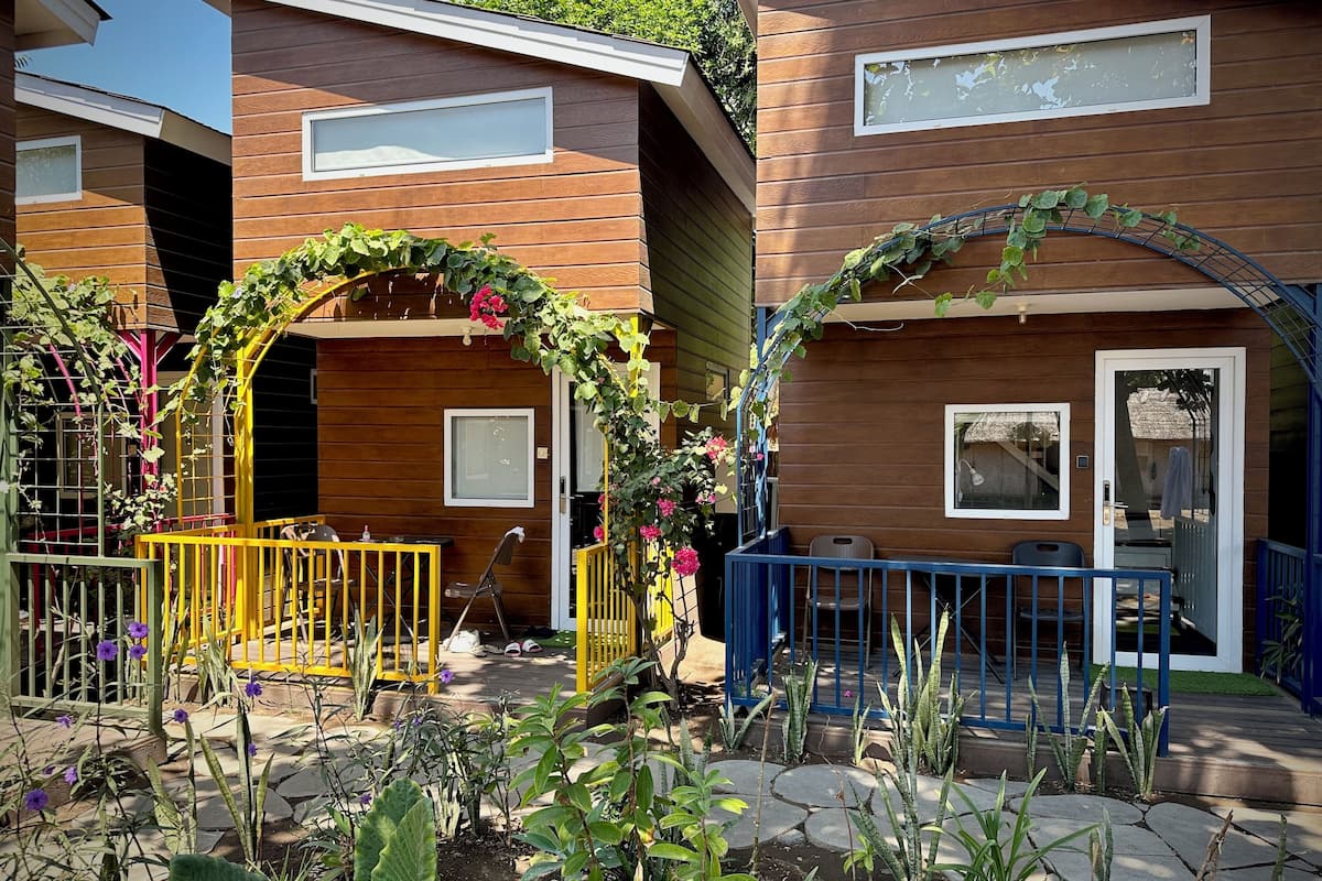 Une maison moderne en bois dotée d’un patio avec jardin, d’un espace salon extérieur et d’une petite table.