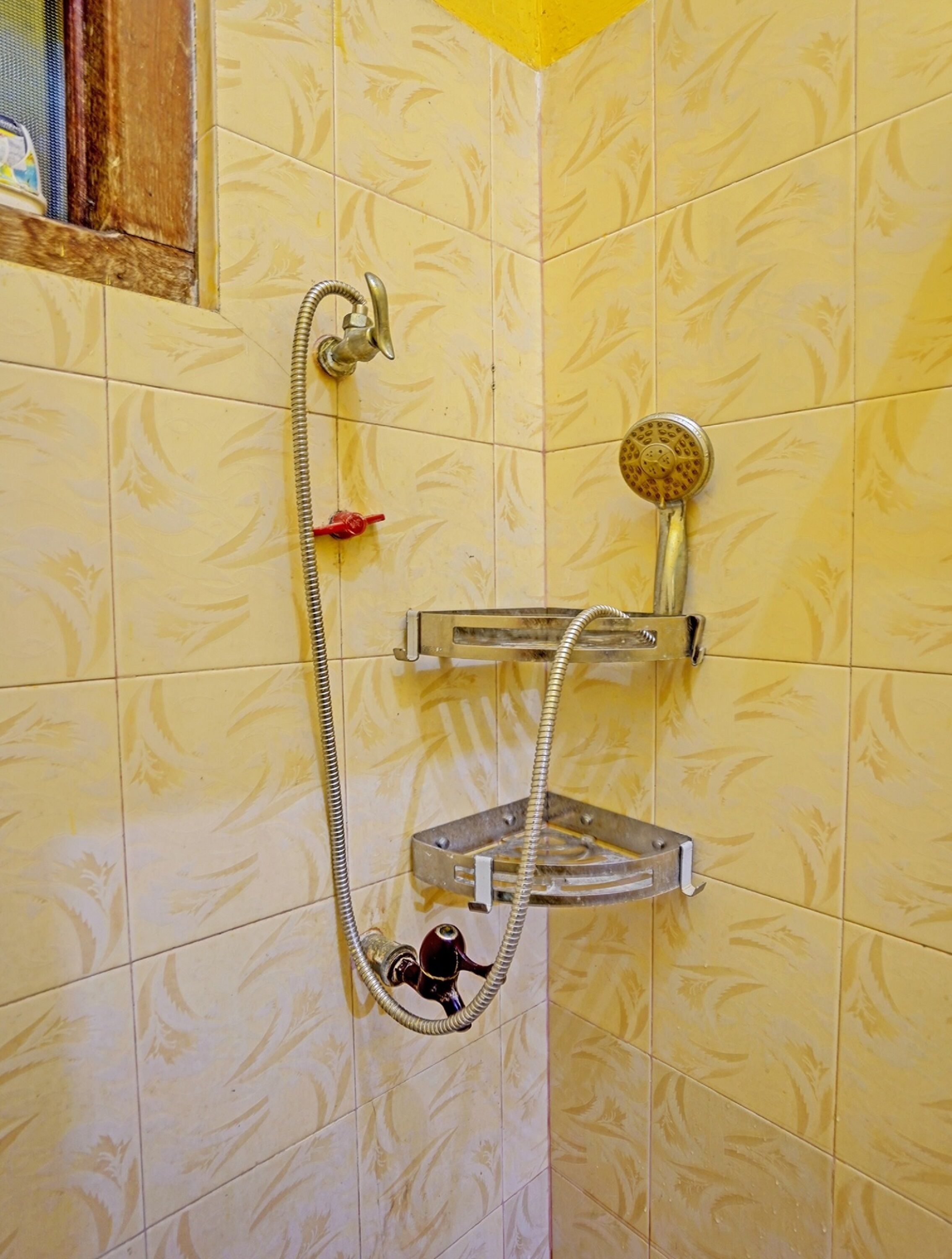 Una ducha con cabezal de ducha de mano y otro fijo en la pared.