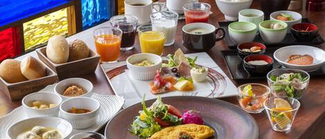 A breakfast buffet with various dishes, drinks, and bread.