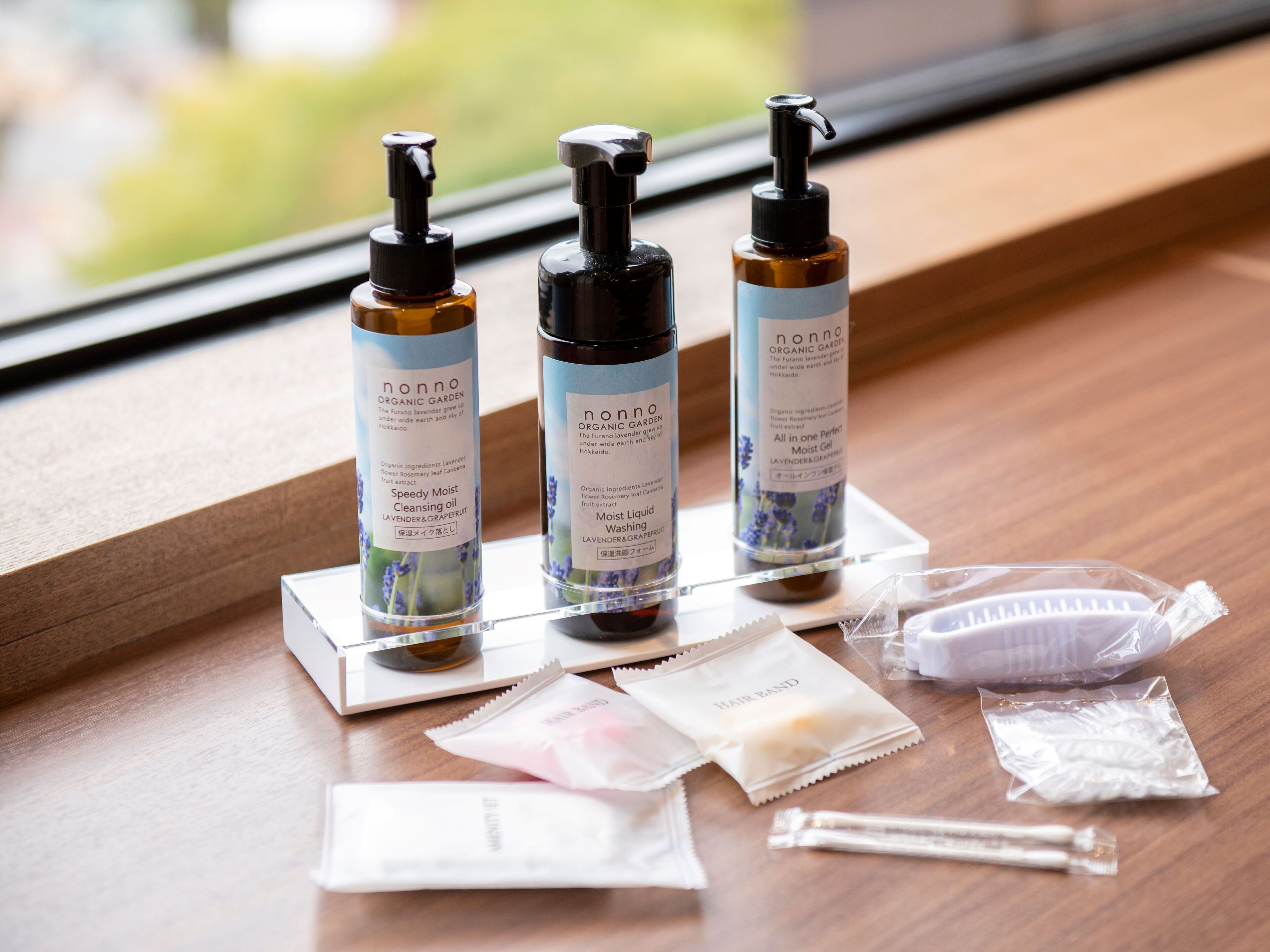 Three nonno organic garden products on a wooden surface near a window.