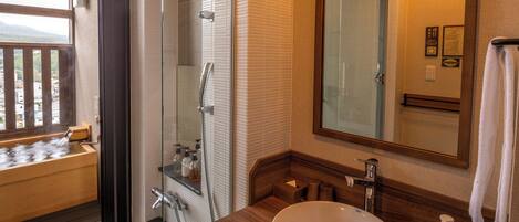 A bathroom with a large sink, mirror, and shower.