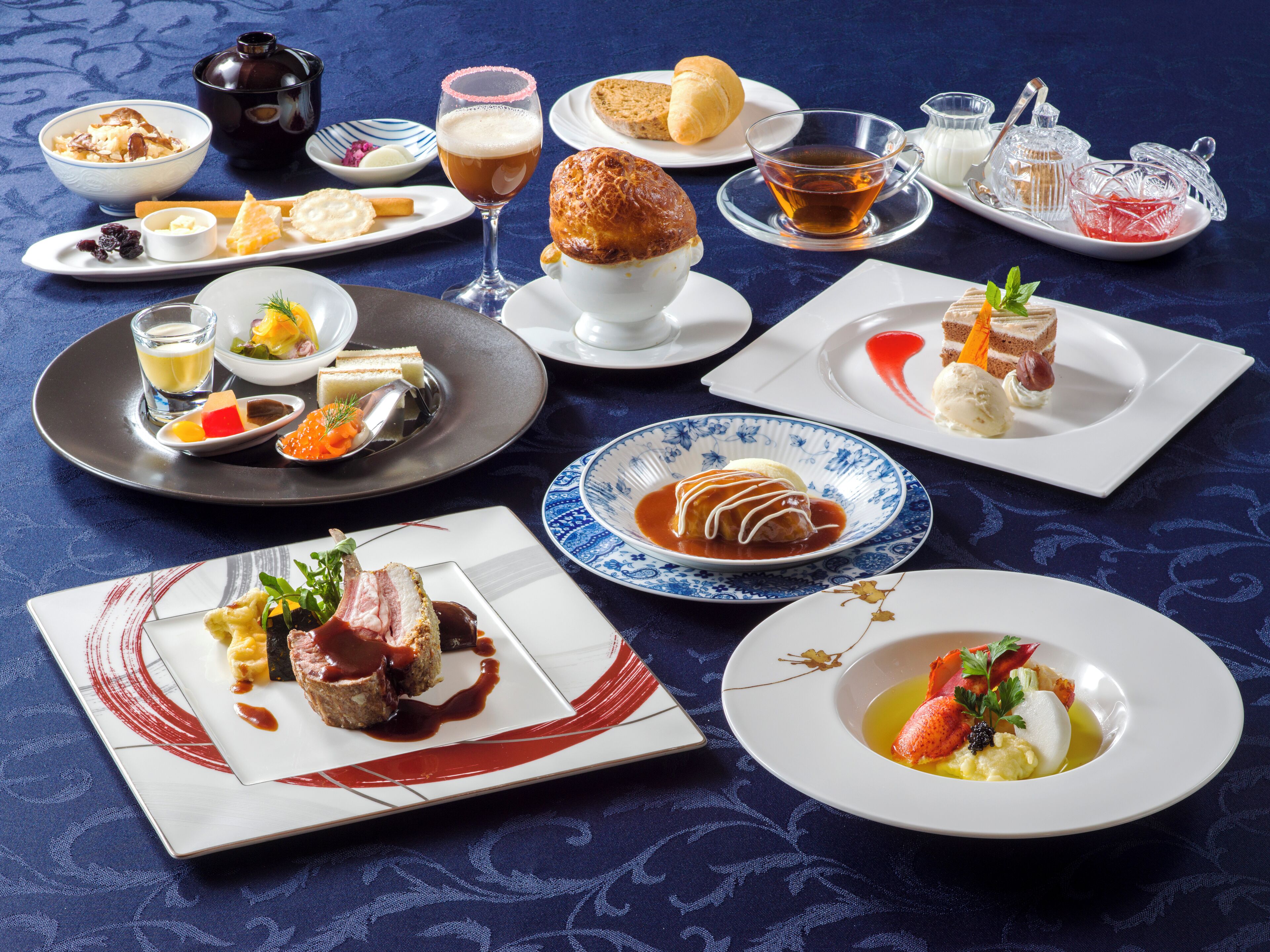 Diverse gerechten op een tafel, waaronder een croissant, een glas bier en een bord met dessert.