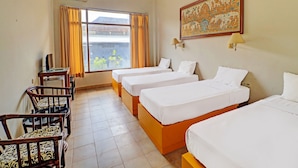 A hotel room with four single beds, a desk with a chair, a window with curtains, and a wall-mounted lamp. - Super OYO 91870 Warna Kedaton (Denpasar)