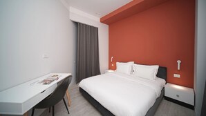 A modern hotel room with a bed, a desk, and a chair. - Cozy 1-Bedroom Apartment in the Heart of Yerevan by Sweet Home (Yerevan)