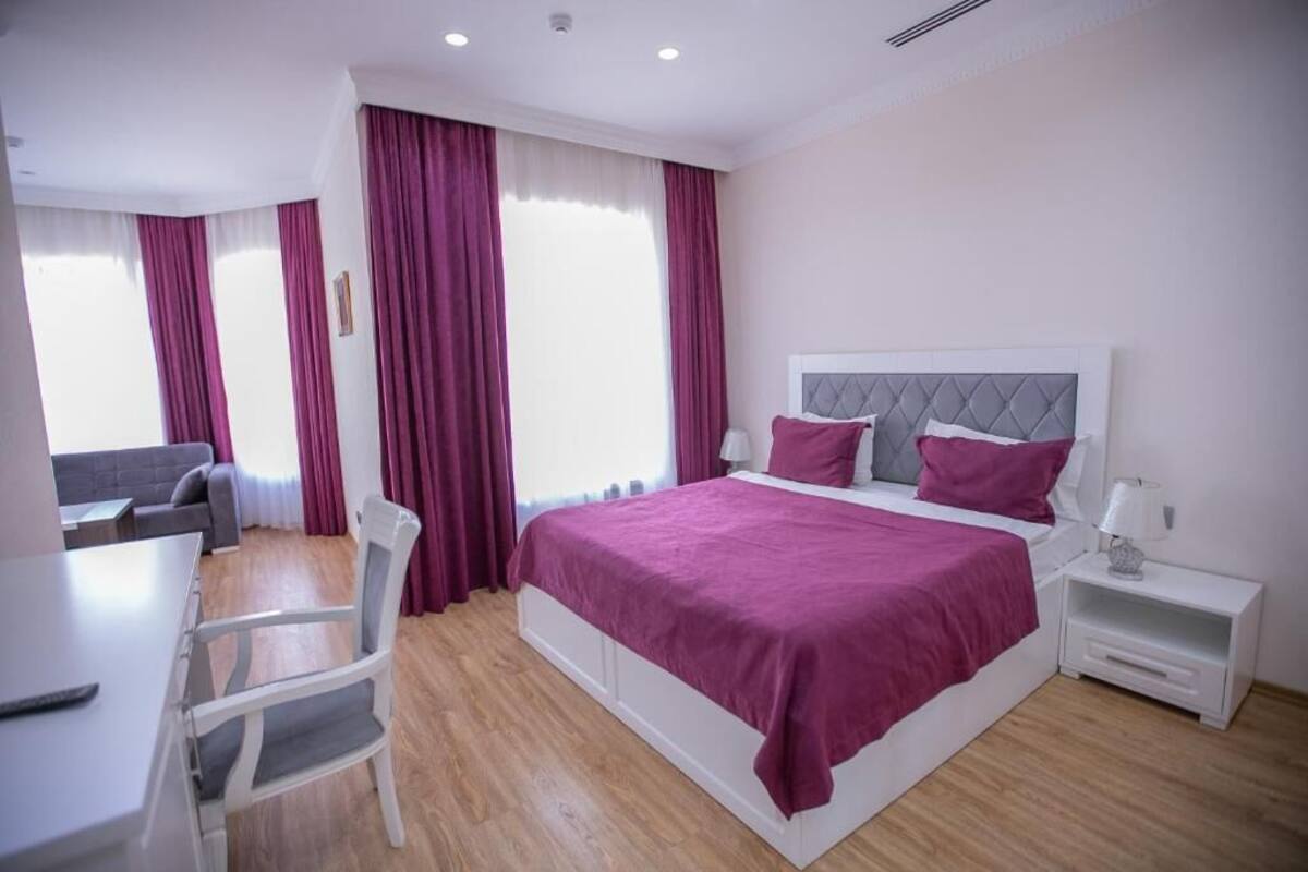 Un dormitorio moderno con una cama grande, un escritorio y una silla.