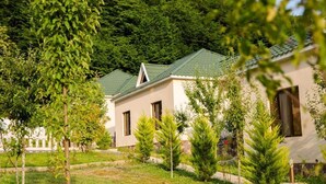 Una fila di edifici moderni a un piano con tetti verdi, circondati da prati curati e alberi giovani.